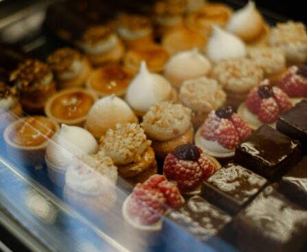 A delectable assortment of French pastries, tarts, and chocolates on display in a bakery setting.